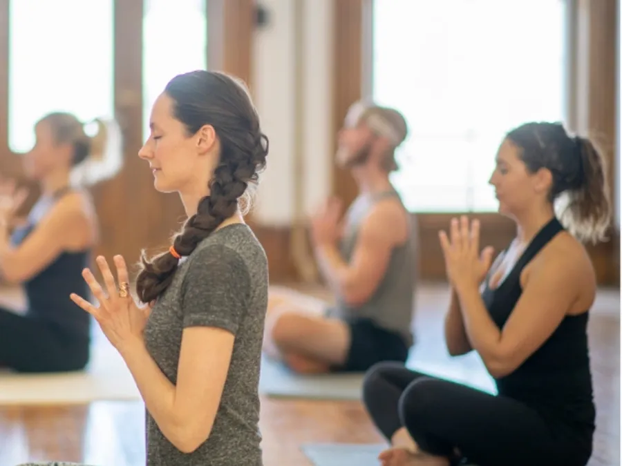 A small group in a seated yoga class at the Hub studio