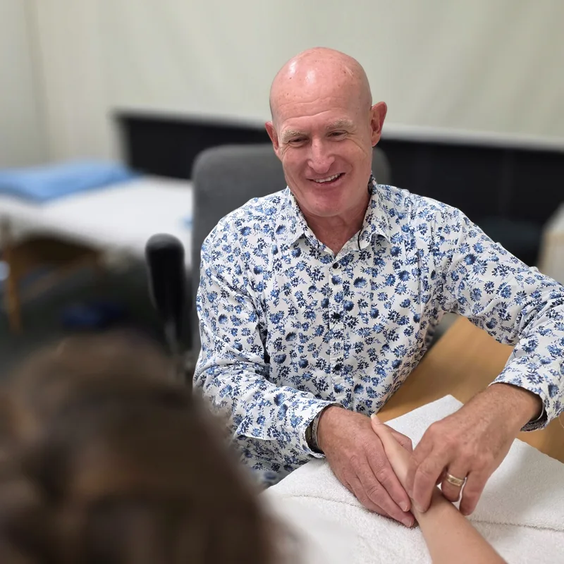 Dr Mal McKay greeting a client at the start of a consultation
